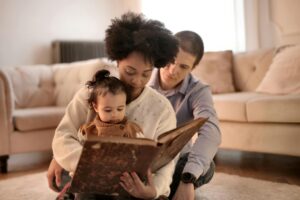 Photo of Woman Holding Brown Book With Her Child